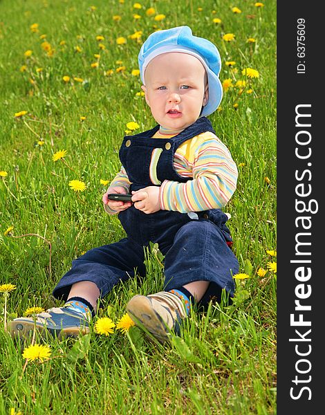 Little child sits on grass