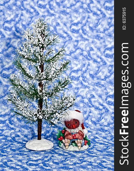 Winter tree with cute cardinal decoration on a blue winter background.