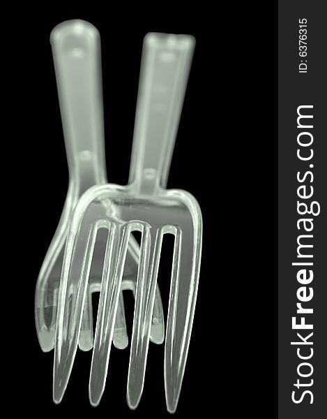 Two transparent plastic forks on black background