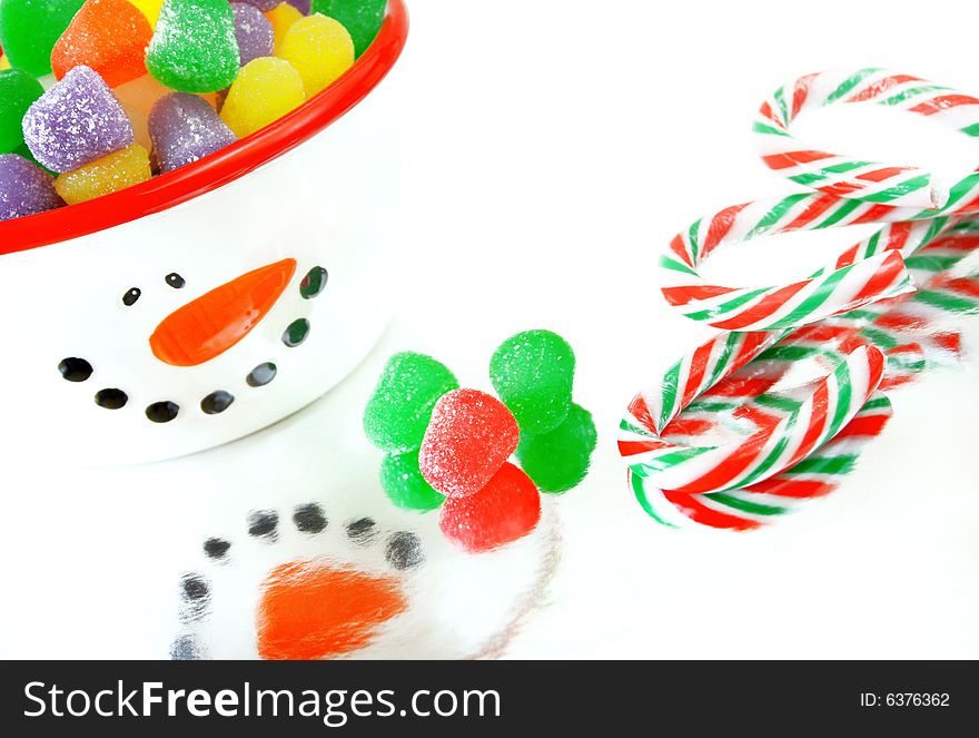 A high key image of Christmas candy.  Candy canes, spice gumdrops and a snowman candy dish.