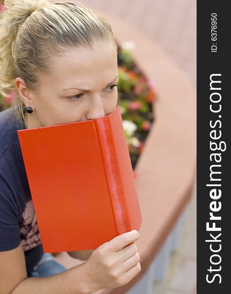 Outdoor outdoor portrait of woman with red book
