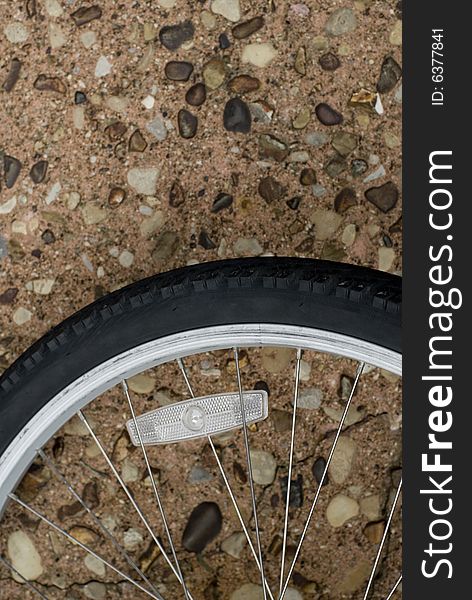 Black bicycle tire laying on rocky road