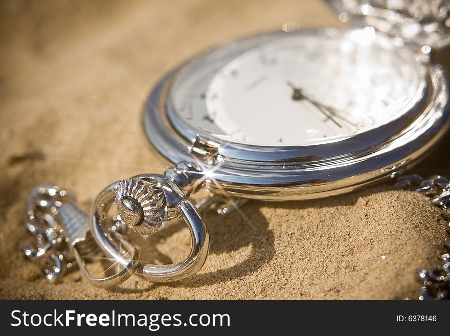 Old pocket watch in sand