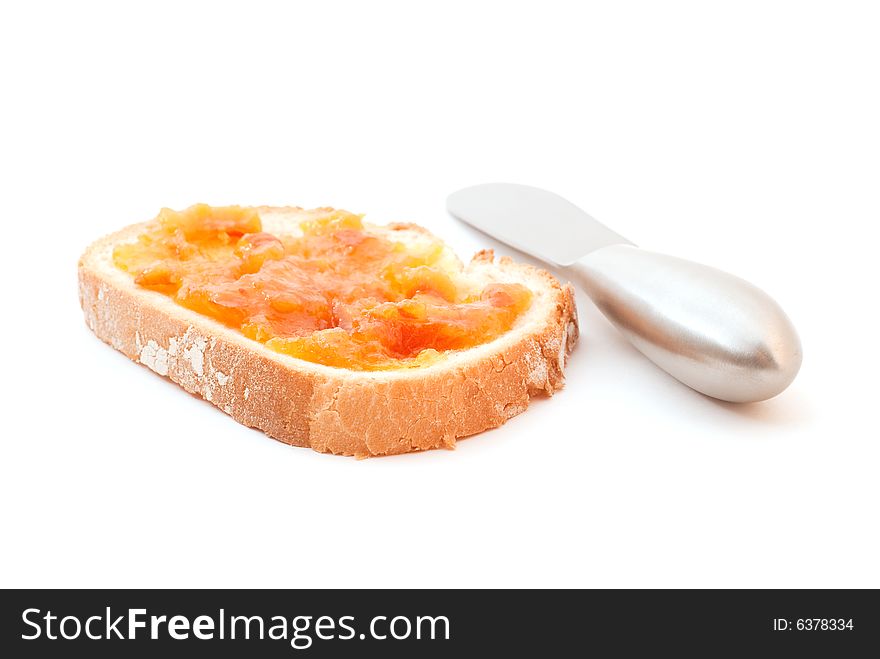 Marmalade on toast next to blunt knife.