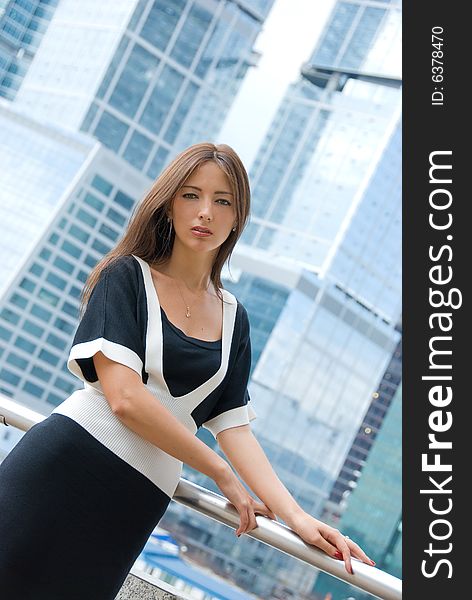 Portrait of young business woman. Modern buildings on the background.