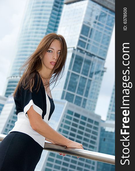 Portrait of young business woman. Modern buildings on the background.