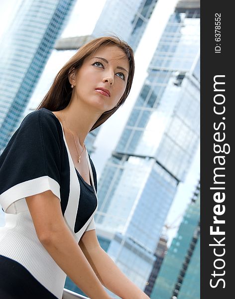 Portrait of young business woman. Modern buildings on the background.