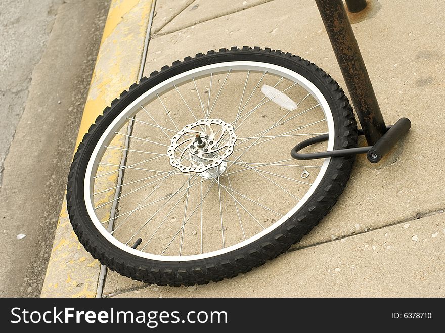 Bike tire locked to brown pole. Bike tire locked to brown pole