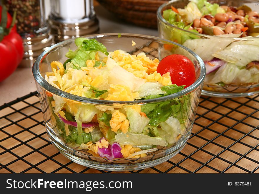 Dinner garden salad in glass bowl in kitchen or restaurant. Dinner garden salad in glass bowl in kitchen or restaurant.