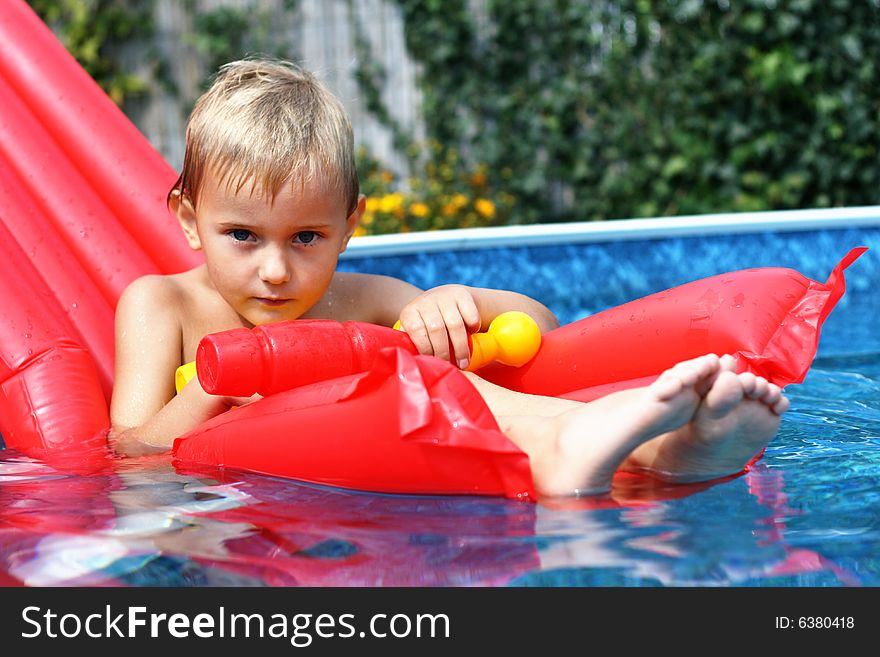 Boy in the swimming pool with toy