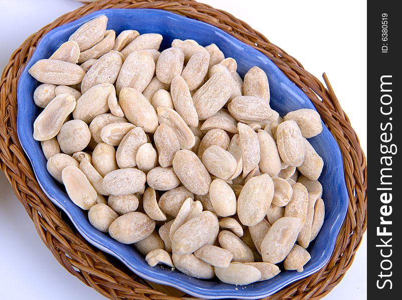 Bowl of salted peanuts isolated on white