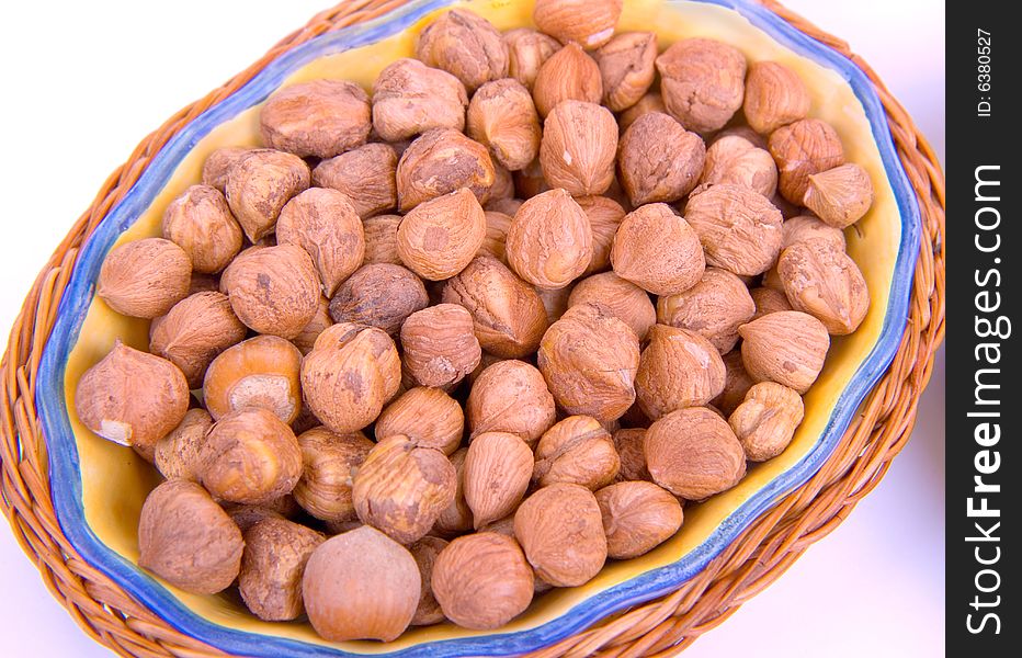 Nuts in a wooden plate on a white background