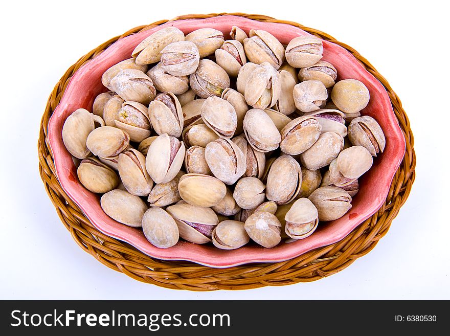 Pistachio nuts in a bowl isolated on white