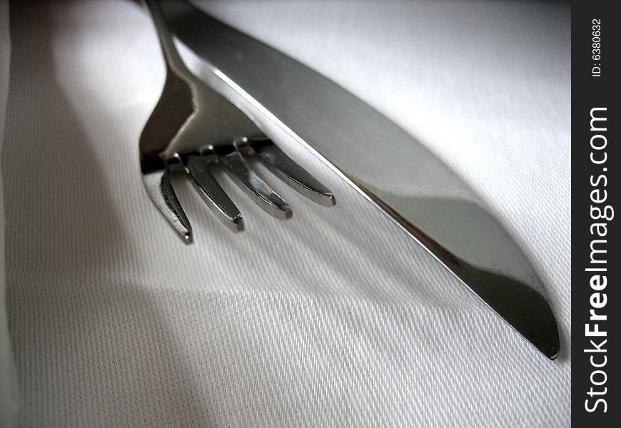 Fork with knife on the white covered table