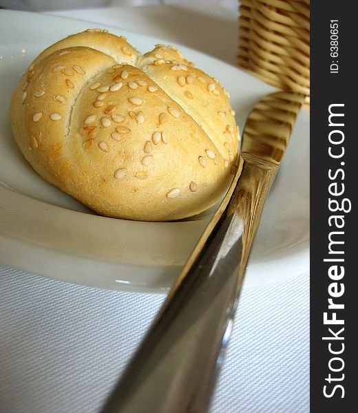 Bun with knife and bread's tidy on a white cover. Bun with knife and bread's tidy on a white cover