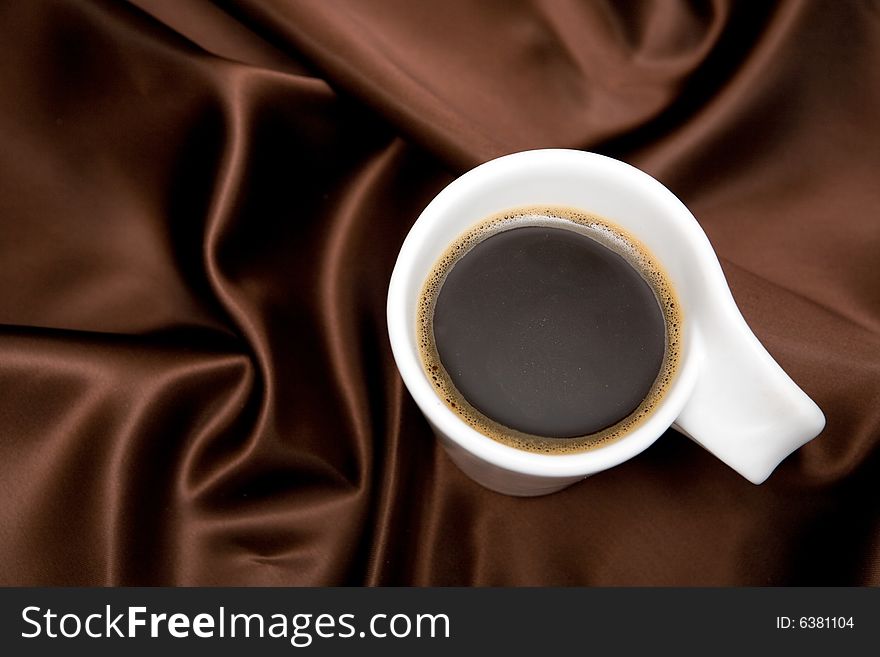 Cup of coffee on brown background