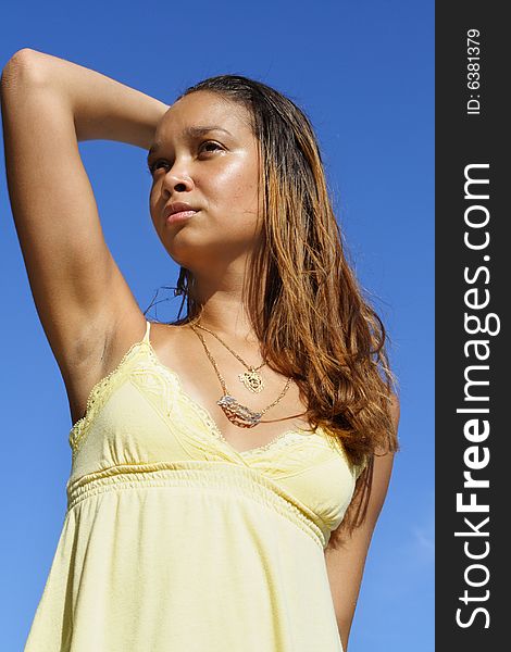 Young woman posing on a blue sky background