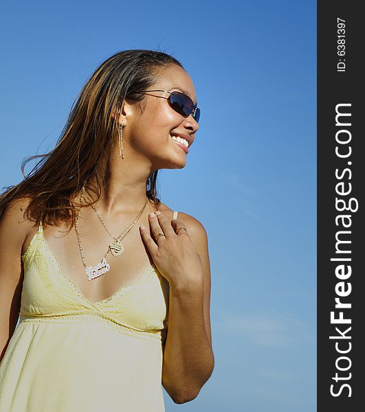 Woman smiling on a blue sky background. Woman smiling on a blue sky background