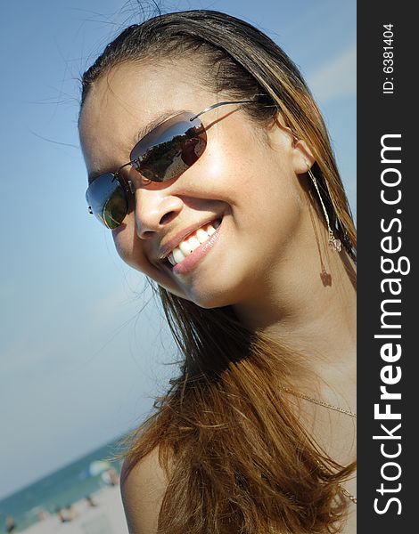 Image of a young woman smiling on a blue sky. Image of a young woman smiling on a blue sky