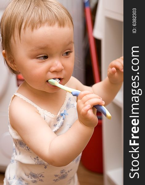 Sweet girl brushing teeth in bathroom