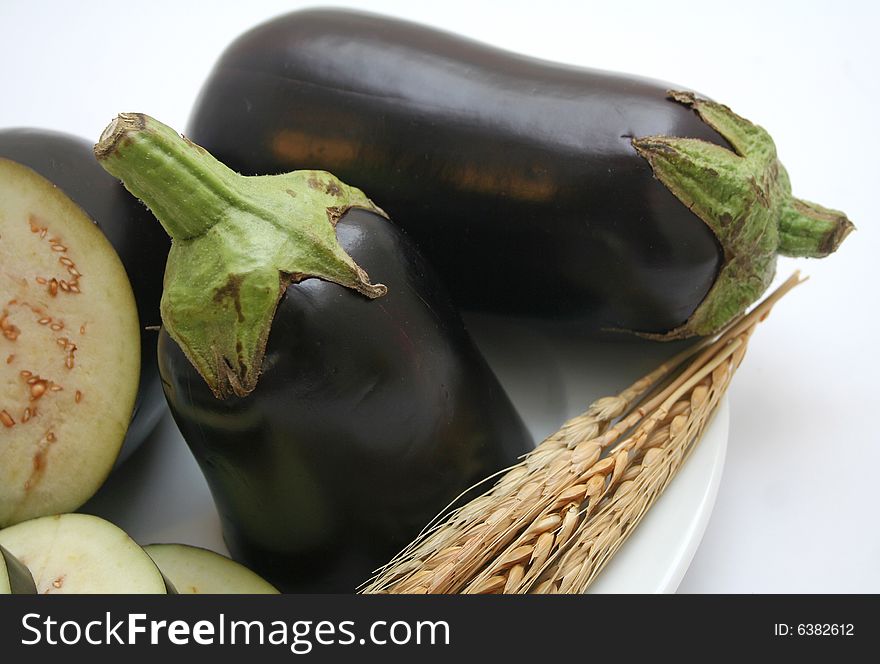 Some fresh, raw aubergines on a plate. Some fresh, raw aubergines on a plate