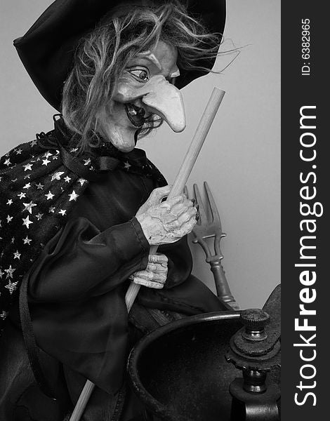 Ugly witch in gray with kitchen utensils. Ugly witch in gray with kitchen utensils