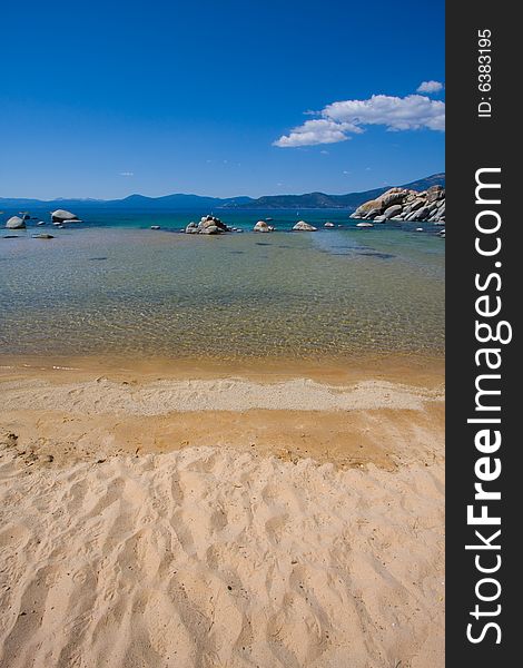 Beach and water, with rocks and blue sky