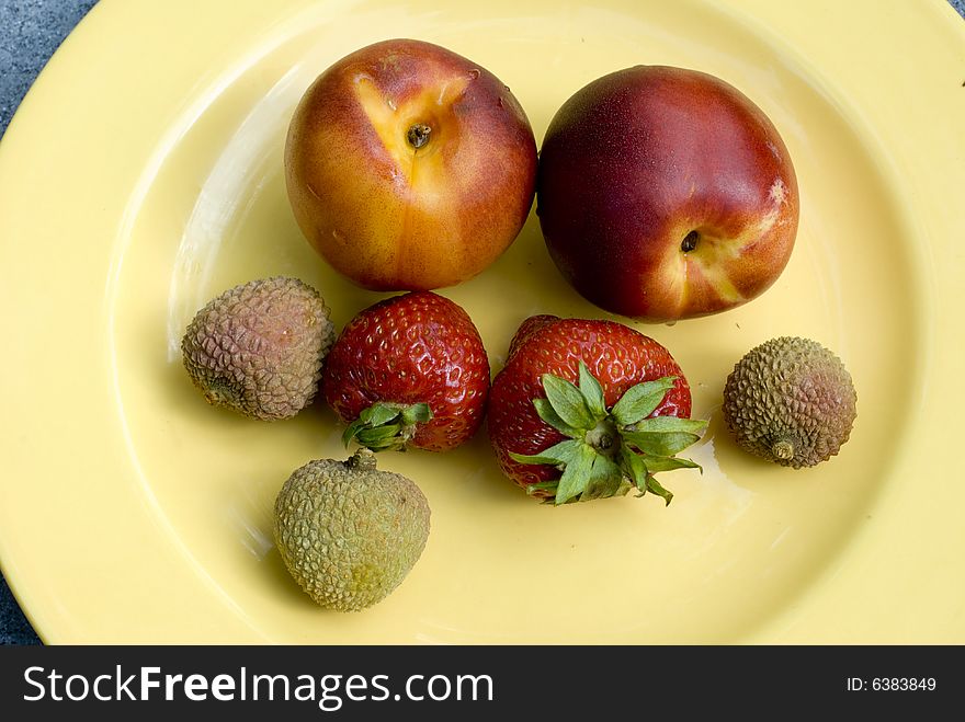 Nectarines, strawberries and lychees on a plate. Nectarines, strawberries and lychees on a plate