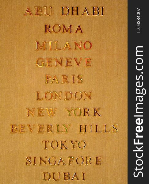An image with famous city names on a wood surface in gold. An image with famous city names on a wood surface in gold.