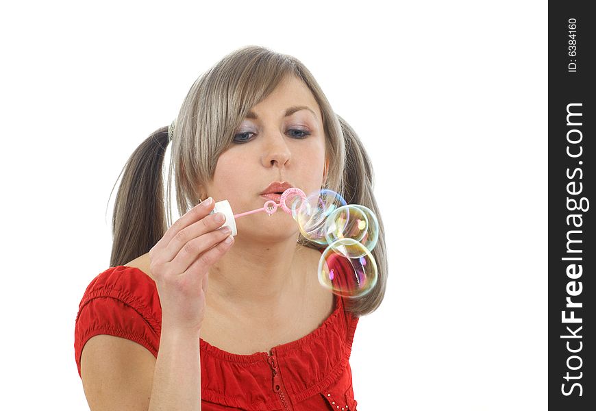 Blonde girl blowing bubbles isolated on white