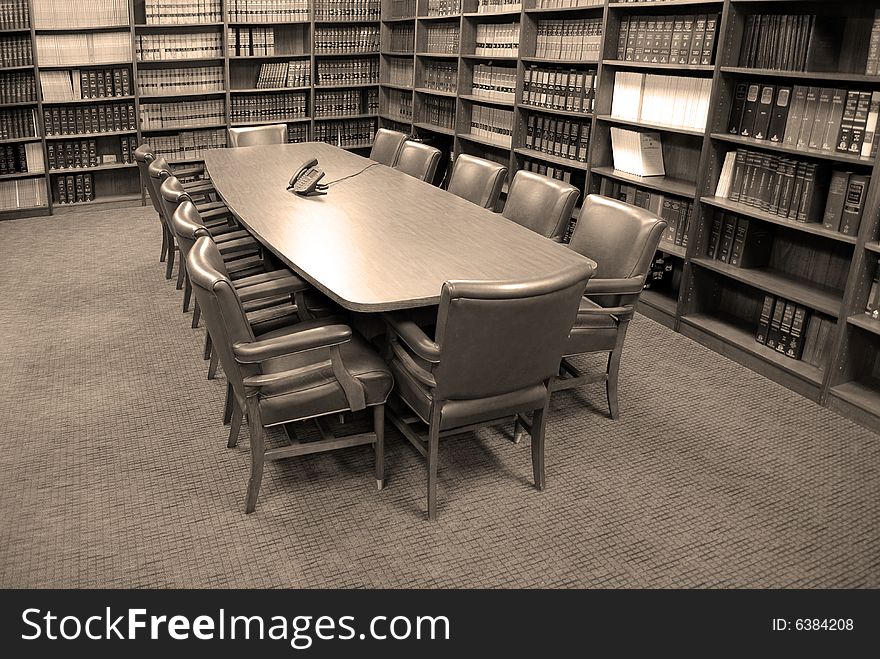 Conference room table with several leather chairs and shelves of books. Conference room table with several leather chairs and shelves of books