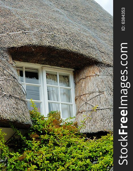 Window of Old English house with straw roof