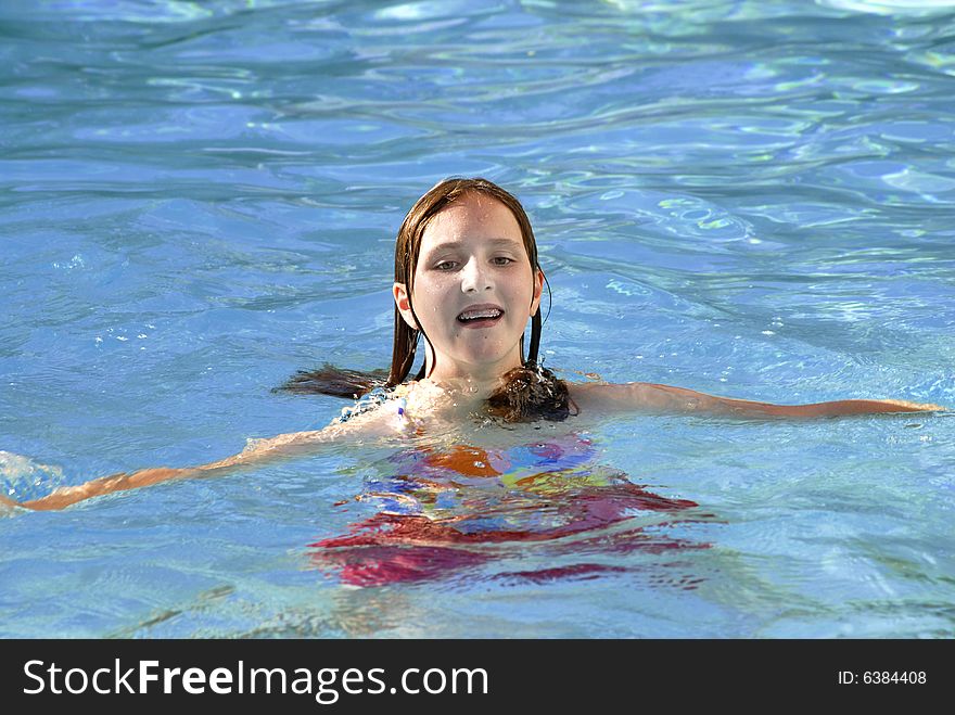 Young girl swimming in a swimming pool. Young girl swimming in a swimming pool
