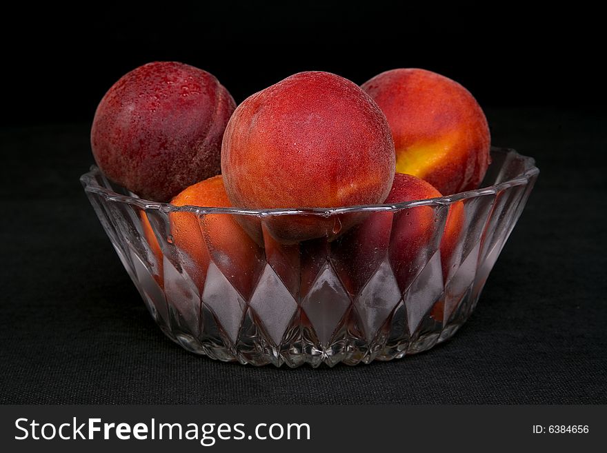 Shot of a freshly washed bowl of peaches in a crystal bowl.