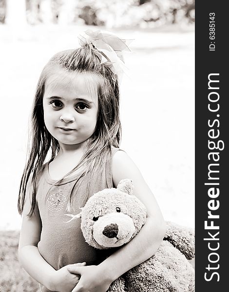 Beautiful little girl with her very best friend, her teddy bear, in tow in brown tones. Beautiful little girl with her very best friend, her teddy bear, in tow in brown tones.