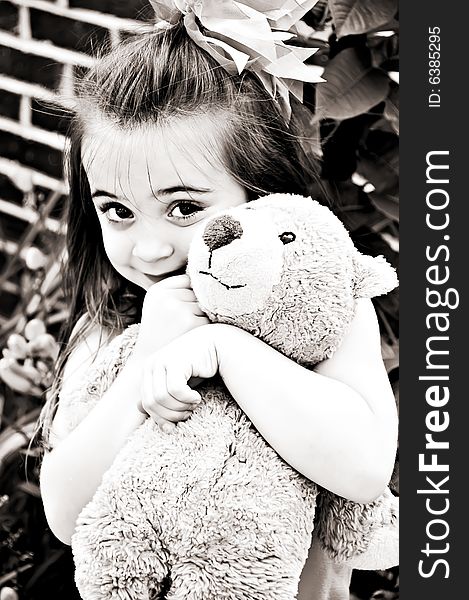 Beautiful young girl posing with her best friend, her Teddy Bear, in an outdoor setting. Beautiful young girl posing with her best friend, her Teddy Bear, in an outdoor setting.