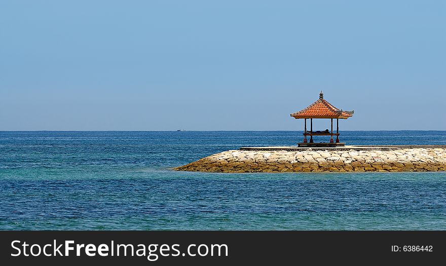 Sea view from the beach with a person relaxing in the shelter. Sea view from the beach with a person relaxing in the shelter