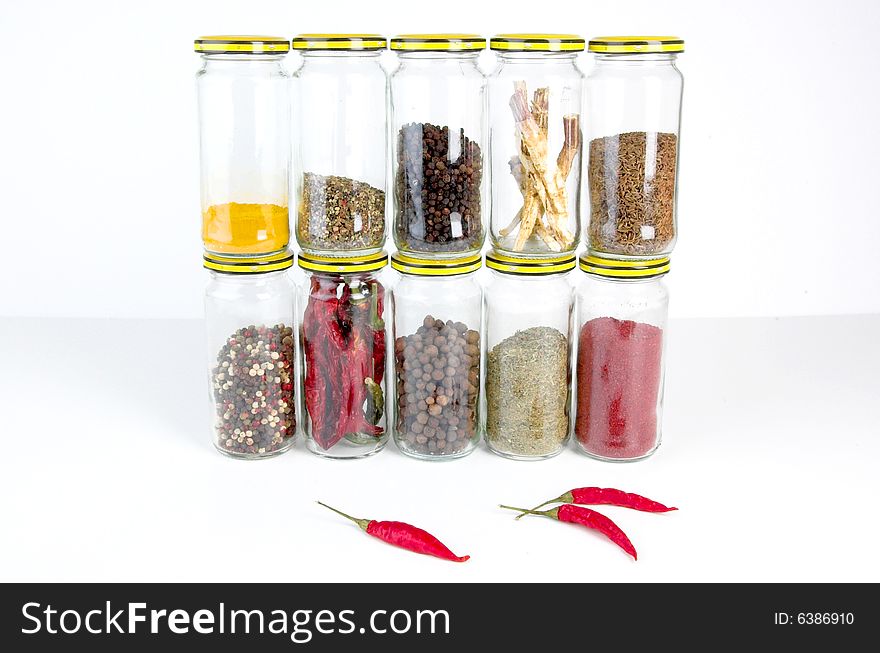 A row of spices on a white background