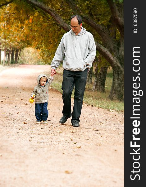 Father and son walking in park. Father and son walking in park