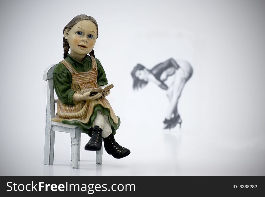 A doll on a chair with a woman in background. A doll on a chair with a woman in background