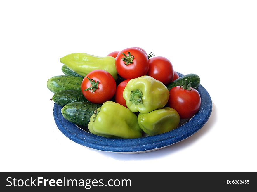 Fresh tomato, sweet peper  and cucumber on country style plate isolated on white background. Fresh tomato, sweet peper  and cucumber on country style plate isolated on white background