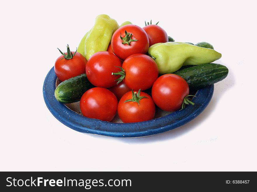 Fresh tomato, sweet peper  and cucumber on country style plate isolated on white background. Fresh tomato, sweet peper  and cucumber on country style plate isolated on white background