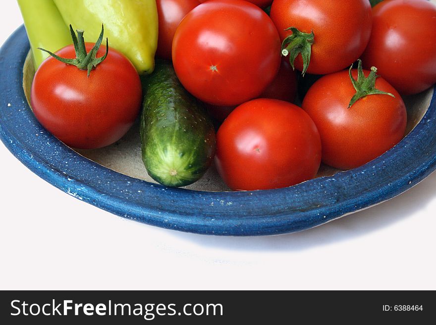 Fresh tomato, sweet peper and cucumber on country style plate isolated on white background