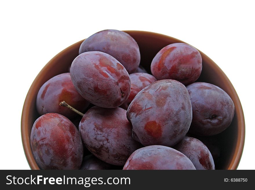 Plums on plate isolated on white background