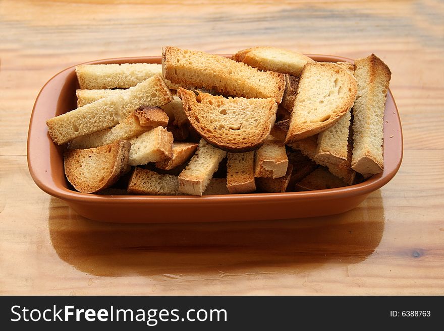 Crackers in brown bowl on wooden table