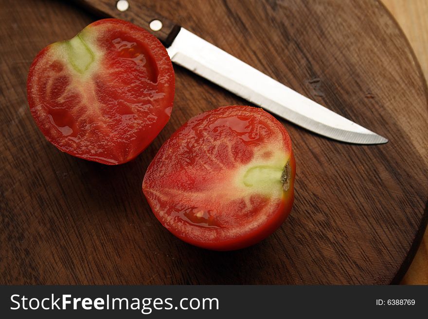 Fresh Tomato With Knife On Kitchen Board