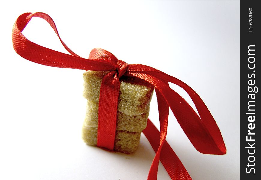 Brown peaces of sugar tied up with a small red ribbon. Brown peaces of sugar tied up with a small red ribbon