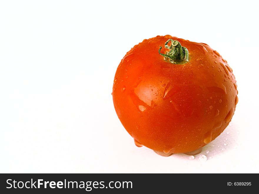 Tomato on a white background with drops of water