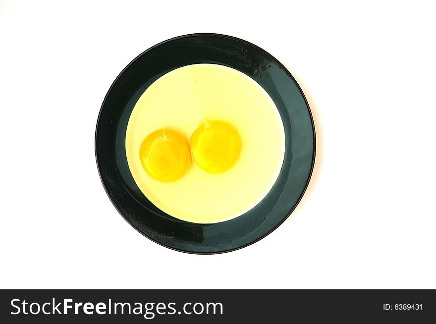 Two crashed eggs in the  plate.