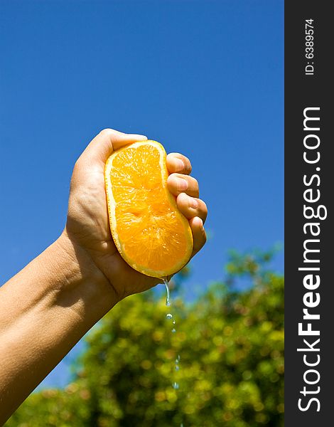 Male hand squeezing an half orange. Male hand squeezing an half orange